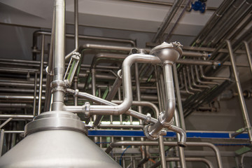 A large vat and pipes at the plant for production of milk