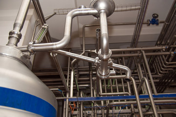 A large vat and pipes at a modern factory for the production of milk
