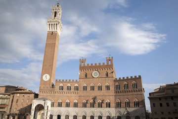 Fototapeta premium Torre del Mangia Tower and the Palazzo Publico Building in the Piazza del Campo Square, Siena