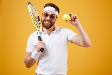 Happy young tennis player showing tennis ball. - Powered by Adobe