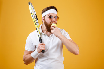 Fototapeta na wymiar Hungry young tennis player bite tennis ball.