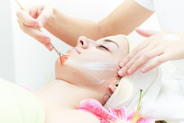 Anti ageing facial mask.Beautiful young woman receiving facial mask at beauty salon