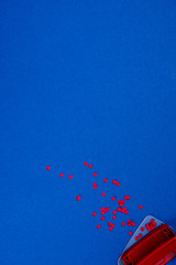 top view of red puncher and paper pieces on blue