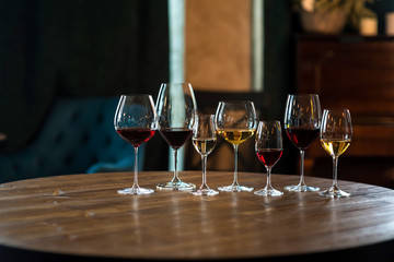 Collection of wine glasses with different wine on wooden table in restaurant. Life style