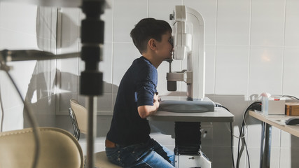 Boy checks eye vision in ophthalmology clinic