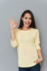 Cheerful young lady showing okay gesture.