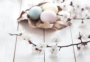 Colored eggs with flowers on a white wooden background. The concept of the holiday of Easter.