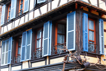 French provencal style windows with vibrant blue wooden shutters. Alsace, France.