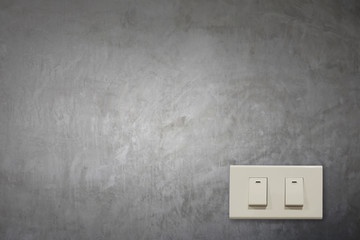 White electric switch on cement wall.