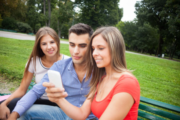 Obraz premium Friends looking at a smartphone