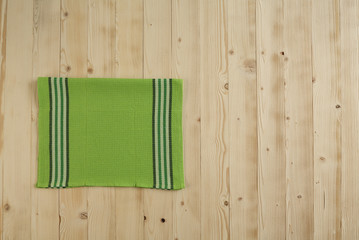 Wooden picnic table with green dishcloth on