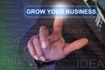 Fototapeta na wymiar Businessman touching GROW YOUR BUSINESS button on virtual screen