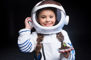Girl astronaut holding plant © LIGHTFIELD STUDIOS