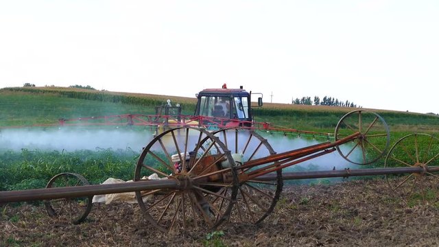 The tractor pulls machine for a spraying in a field of paprika.