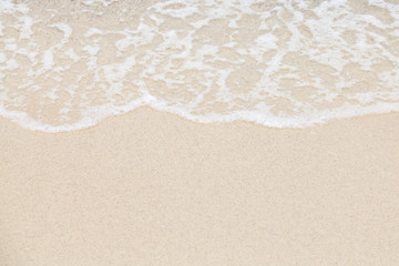 Fototapeta na wymiar Soft wave of ocean on sandy beach. Background.