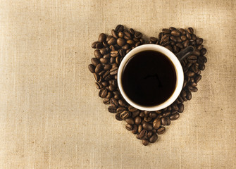 Cup with coffee and heart of coffee beanes