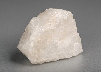 Mineral  milky quartz on gray background. Quartz crystals have piezoelectric properties.