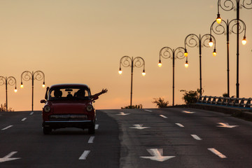 Old car on street of Havana with the driver saluting from his car, Cuba