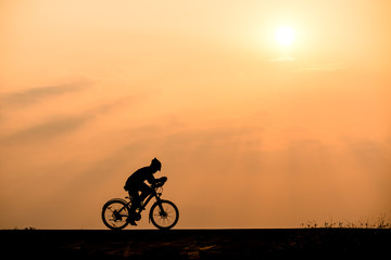 Fototapeta na wymiar Silhouette of cyclist on sunset background