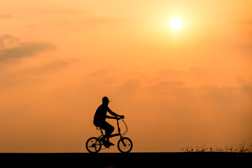 Obraz premium Silhouette of cyclist on sunset background
