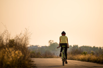 Silhouette of cyclist on sunset background