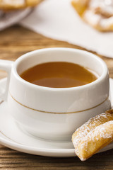 Elegant tea cup and faworek for a dessert