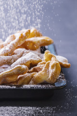 Sprinkling powdered sugar on faworki