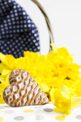 Spring composition of a cookie, daffodils and willow basket