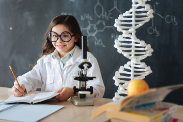 Positive little researcher enjoying microbiology experiment in the laboratory
