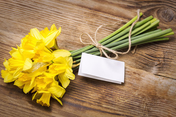 A bouquet of daffodils tied with rope on a wooden table