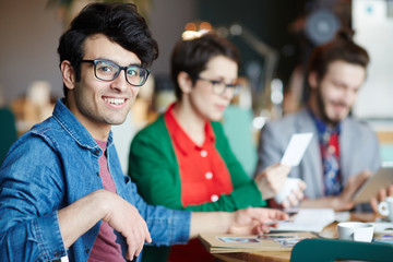 Fototapeta premium Young creative designer in eyeglasses looking at camera during work