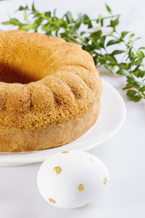 Easter bundt cake and a decorative egg on a white table