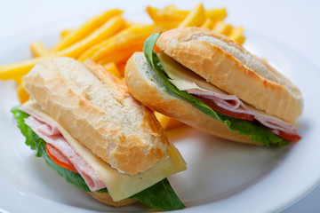 Sandwich with ham, tomato, cheese and golden French fries potatoes