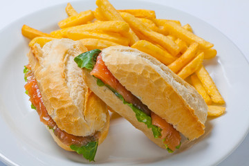Sandwich with salmon, tomato, cheese and golden French fries potatoes