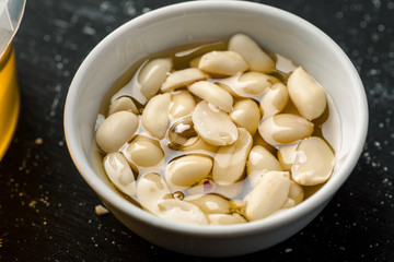 Raw peanuts in a white bowl filled with honey