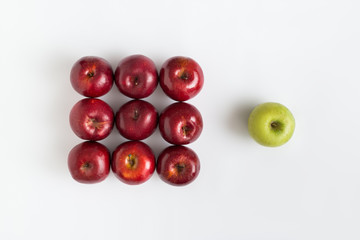 Top view of one green apple among red apples