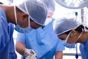 Fototapeta na wymiar Group of surgeons performing operation in operation room