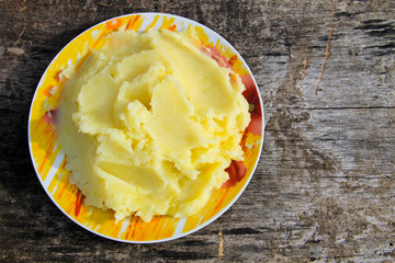 Mashed potatoes in a plate on rustic wooden table