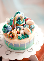 Birthday cake with cupcakes, macaroons and sweets closeup. Selective focus. Celebration.