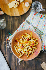 Poutine fries on black surface. Canadian dish with potatoes, cheese and sauce.