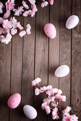 Branches of cherry tree with decorative easter eggs on wooden table