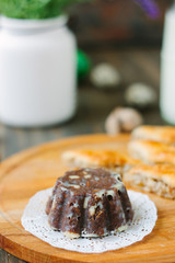 Chocolate cake on wooden board over dark background.