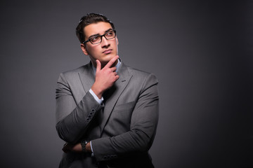 Handsome businessman against dark background