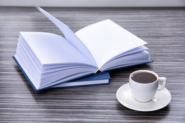 Book and cup of coffee on wooden table