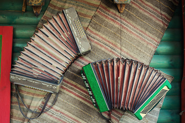 Vintage accordion,harmonica hanging on the wall,music concept,Wooden walls and Accordion,chromatic harmonica type instrument.