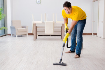 Man husband cleaning the house helping his wife