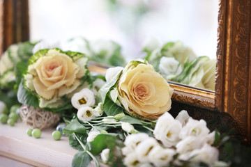 Beautiful fresh flowers lying near mirror, closeup
