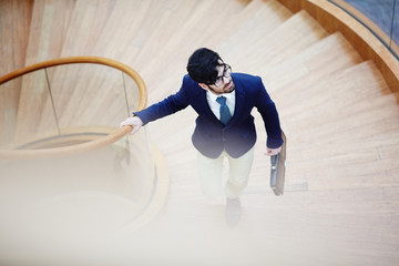 Serious man in suit walking upstairs