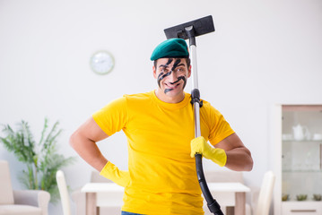 Funny man in military style cleaning the house