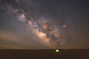 A lit up tent under the night sky 